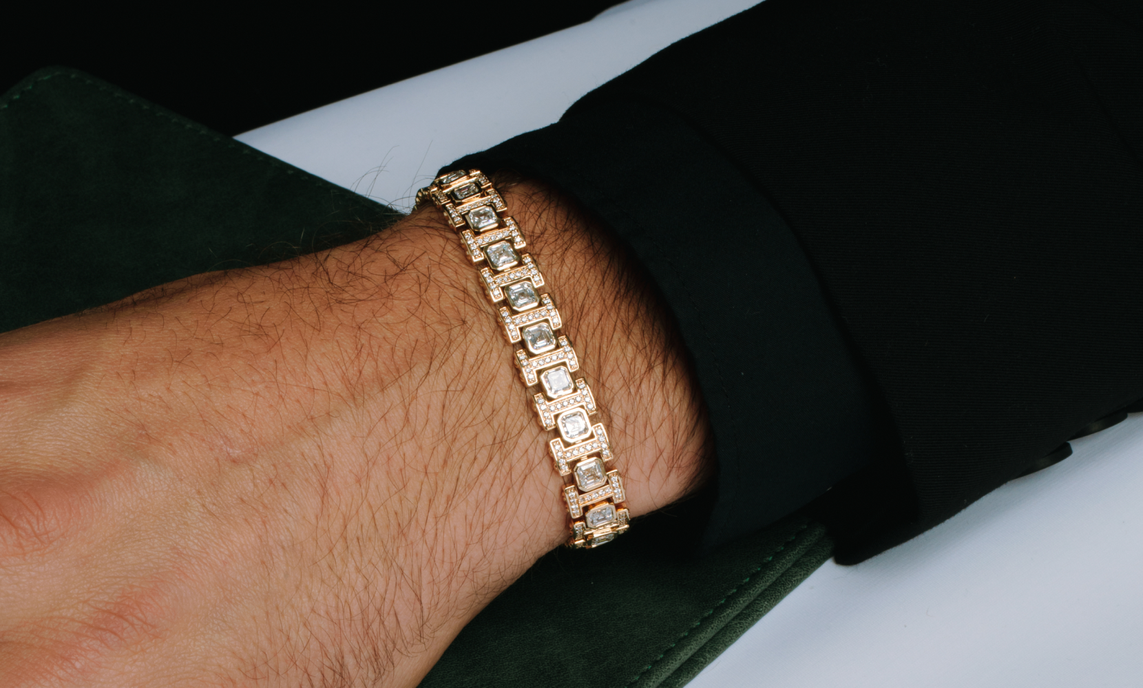 Image of a male model's neck and chest featuring a men's bracelet and a diamond cross necklace